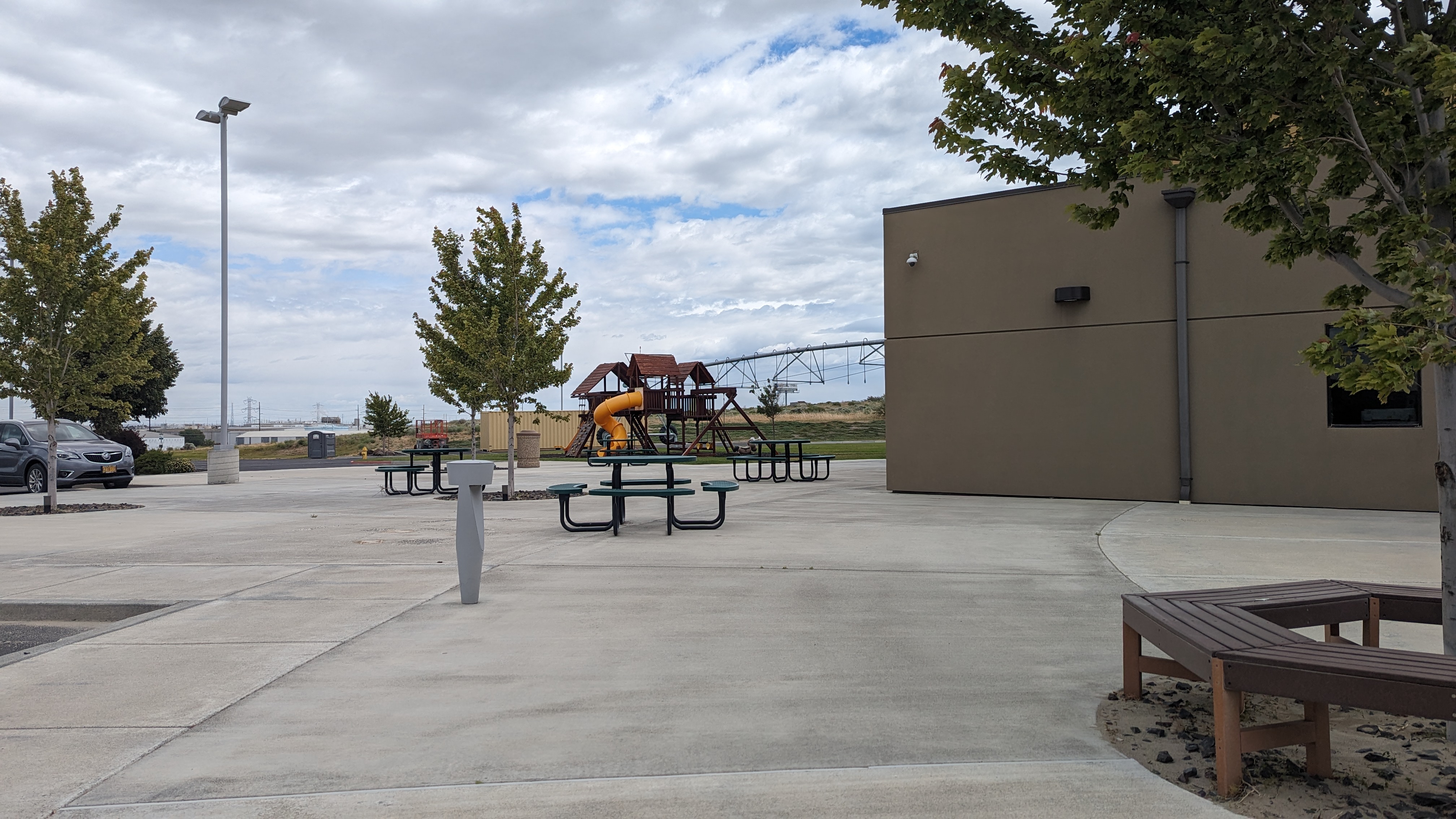Playground, seating and picnic tables outside in front.